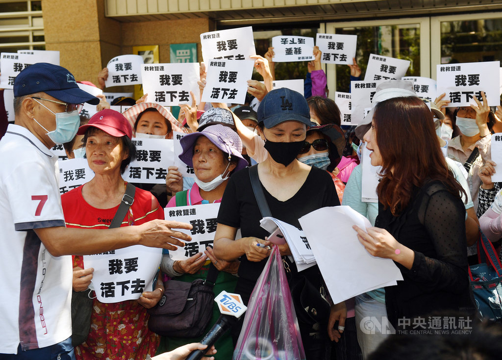 雙連商圈自救會22日到台灣民眾黨立院黨團辦公室外舉牌抗議,由民眾黨團主任陳琬惠(前右)出面接下陳情書,允諾將轉達給身兼民眾黨主席的台北市長柯文哲。中央社記者施宗暉攝 109年6月22日