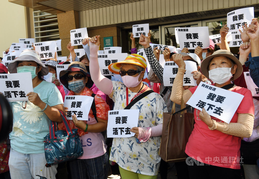 數十名雙連市集攤商22日在立法院青島東路民眾黨黨團辦公室外,舉看板呼口號抗議,指台北市長兼民眾黨主席柯文哲強制驅離攤商,且無配套措施。中央社記者施宗暉攝 109年6月22日