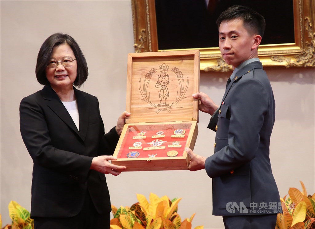 109年三軍六校院授證、授階暨頒獎典禮23日在總統府舉行,畢業生呈獻三軍六校院畢業生旗徽給總統蔡英文(左),木盒內側並刻上貓咪圖樣,展現年輕人創意。中央社記者鄭傑文攝 109年6月23日