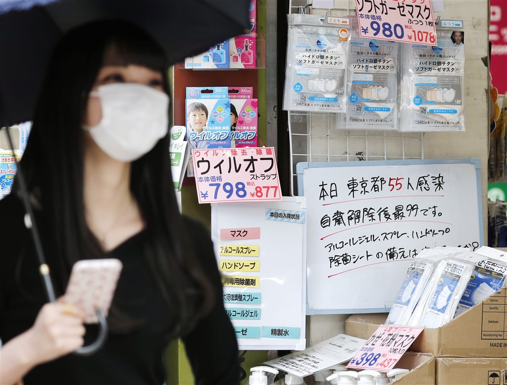 日本武漢肺炎疫情最嚴重的東京都24日新增55人確診,是自大型連休期間的5月5日以來再度出現單日確診超過50人。圖為東京新宿藥妝店在門口掛白板寫上疫情最新情況。(共同社提供)
