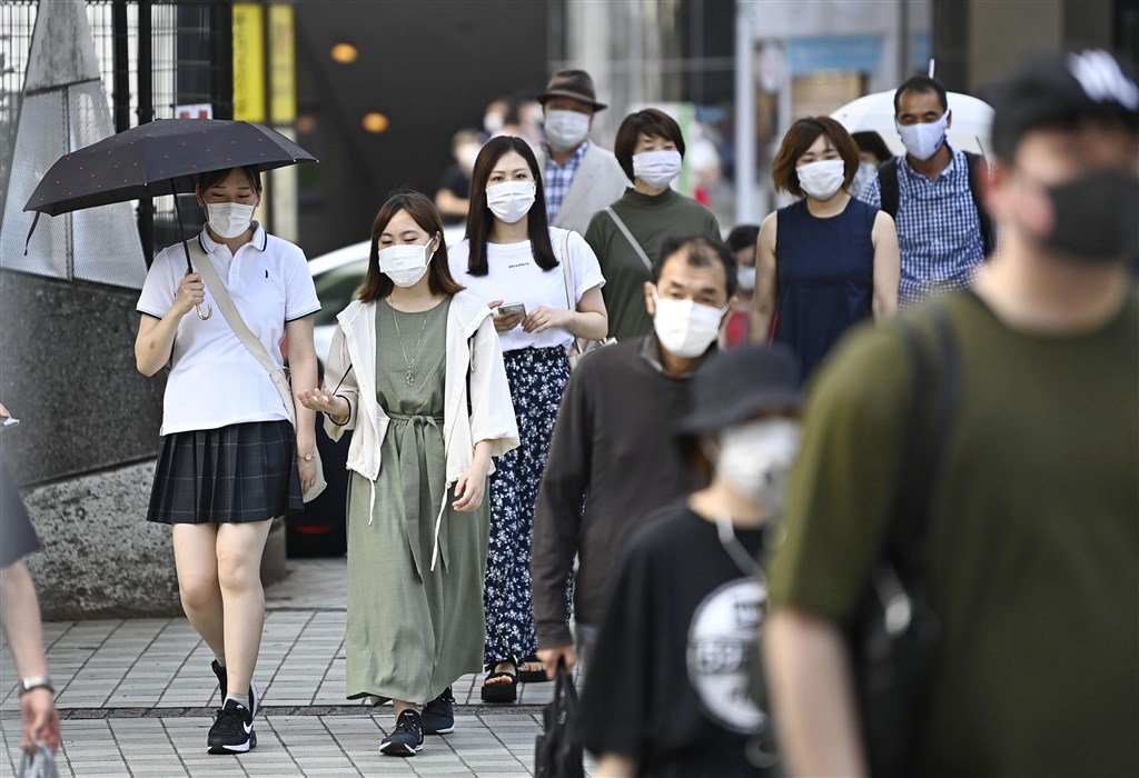 共同社報導,日本26日新增破百起武漢肺炎感染病例,為5月9日以來首見。圖為新宿車站前民眾戴口罩防疫。(共同社提供)