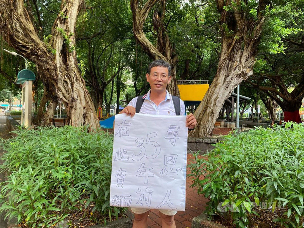 屏東市建國國小校長施世治(圖)35年前在台北市區補習時,經常光顧的麵攤老闆娘總會多加餛飩給他,讓他感念在心,今年特別利用端午連假重返舊地,拿著大字報盼找當年默默關懷他的「餛飩麵媽媽」。(施世治提供)中央社記者郭芷瑄傳真 109年6月27日