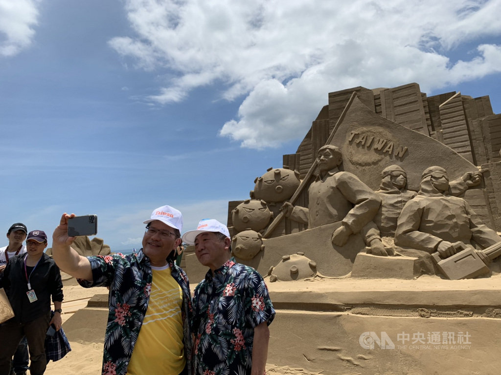 交通部長林佳龍(右2)與衛福部長陳時中(右)29日出席2020福隆國際沙雕藝術季活動,兩人在防疫國家隊的沙雕前自拍。中央社記者葉臻攝 109年6月29日