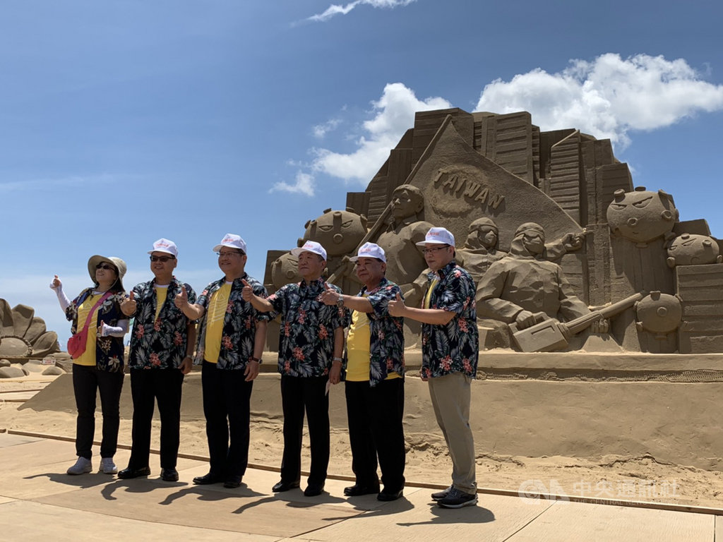 2020國際福隆沙雕藝術季以「巨人的夢遊世界」為主題,自5月30日舉辦至今,參觀人次已突破6萬人,交通部長林佳龍(左3)與衛生福利部長陳時中(右3)29日在防疫國家隊的沙雕前比讚合影。中央社記者葉臻攝 109年6月29日