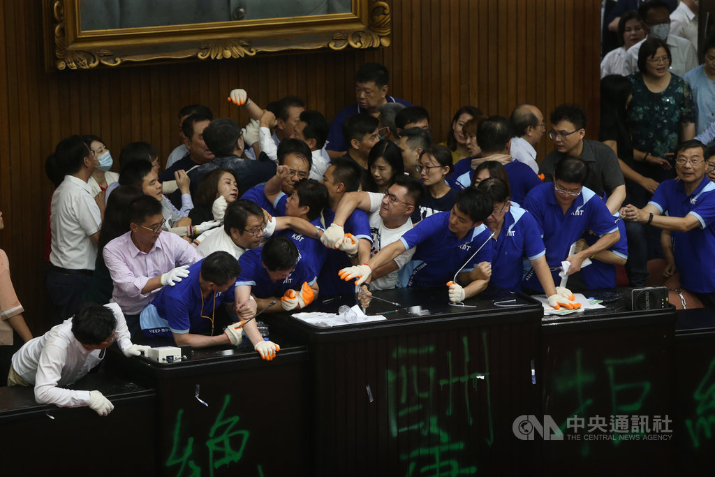 國民黨立委29日持續占領議場,原訂上午10時30分舉行談話會,民進黨立委約在上午11時10分排除主席台後方鐵鍊,開門後陸續進入議場,藍綠雙方在主席台前推擠,展開攻防。中央社記者鄭傑文攝 109年6月29日
