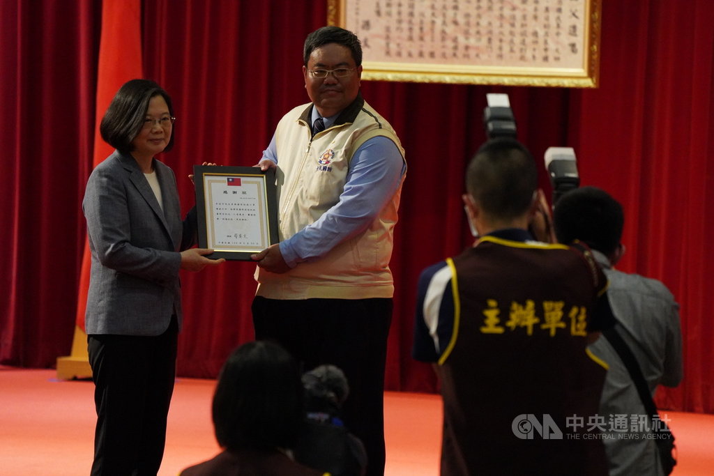 總統蔡英文(後左)29日下午在忠愛營區出席後備指揮部支援口罩增產有功人員表揚典禮,頒發獎狀給口罩增產有功人員。中央社記者徐肇昌攝 109年6月29日
