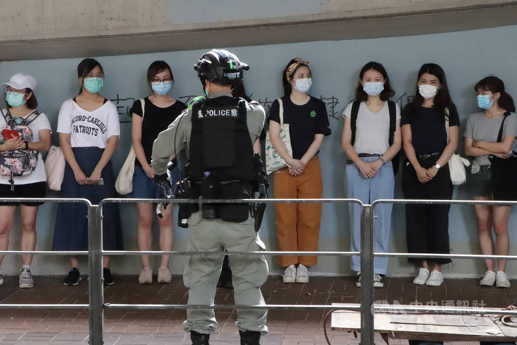 「港區國安法」6月30日深夜生效後,許多港人7月1日走上街頭遊行抗議。由於遊行未獲警方批准,港警在警告後,以涉嫌違反公安條例等逮捕了數十人。圖為警方在灣仔天樂里抓了20多人。中央社記者張謙香港攝 109年7月1日