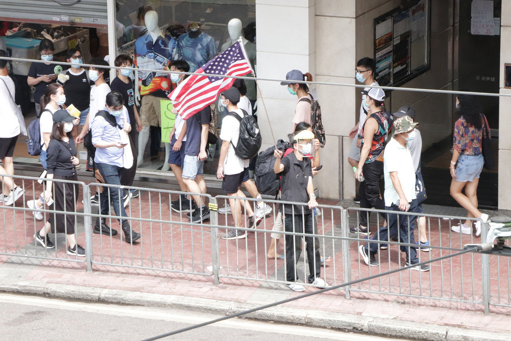 港區國安法生效後的第一個「七一」紀念日,民眾自發上街,在銅鑼灣崇光百貨一帶等多個地點進行抗議示威,其中有人舉起美國國旗。香港國安法對勾結境外勢力明訂刑責。中央社記者張謙香港攝 109年7月1日