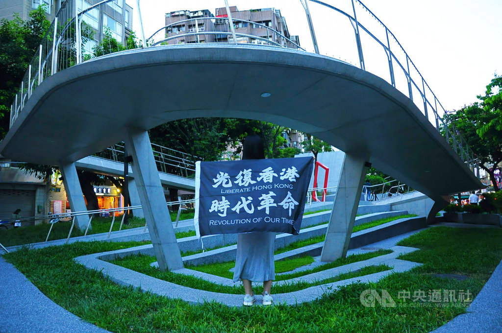 流亡來台的「反送中」示威者Lomo說,抗爭期間為了照顧年輕示威者,自己隱藏各種情緒,久而久之性格大變,現在正嘗試找回原本的自己。圖為身披「反送中」旗幟的Lomo。中央社記者沈朋達攝 109年7月1日