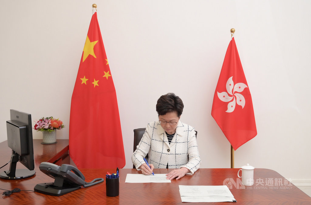 香港行政長官林鄭月娥1日在香港特別行政區成立23週年典禮後致詞時說,過去一年是她40年公務生涯中最嚴峻的考驗,但她感謝北京中央對其信任,相信香港可以否極泰來。圖為林鄭昨晚簽署生效「港區國安法」。(中通社提供)中央社 109年7月1日