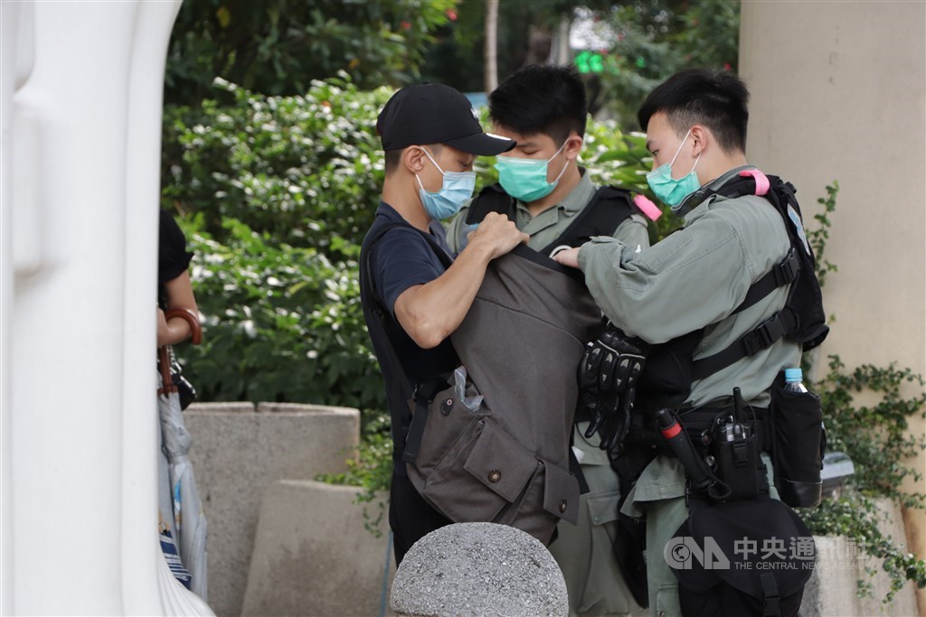 「港區國安法」效力範圍大,組織「台獨」、在台灣犯案都可能適用。一個外國人在外國行使當地的言論自由,主張港獨,在香港也可能會被抓。圖為5月27日防暴警察在灣仔截查可疑示威者。(中央社檔案照片)