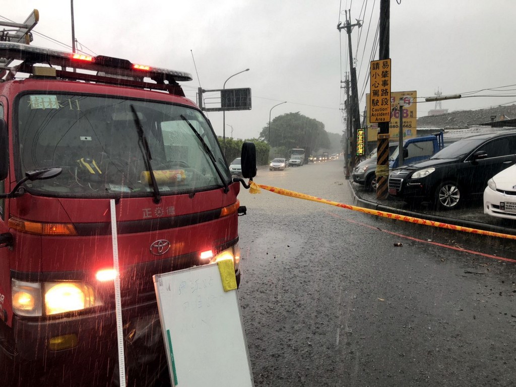 新北市樹林區2日下午降下瞬間大雨,環漢路五段與四維路口有將近100公尺路段積水,最深處達半公尺高,消防車出動警戒並拉起封鎖線,將道路暫時單線封閉。(消防提供)中央社記者黃旭昇新北傳真 109年7月2日