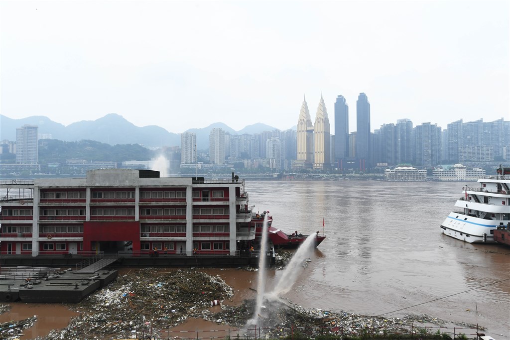 中國長江洪水形成,重慶沿岸因江水上漲堆積飄浮物。(中新社提供)