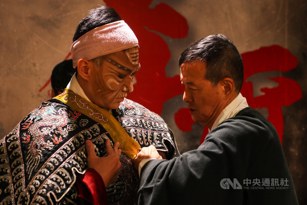 當代傳奇劇場藝術總監吳興國創作的「李爾在此」,將首度在國家兩廳院演出,6日舉行宣傳記者會,演出前吳興國(右)親自替嫡傳弟子朱柏澄(左)整裝,傳承意味濃厚。中央社記者王騰毅攝 109年7月6日