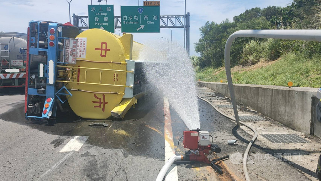 一輛載運鹽酸溶液的大型槽車6日行經台61線北上白沙屯路段,突然失控翻覆,有少量鹽酸外洩,苗栗縣消防局獲報趕往救援,並將受傷駕駛送醫。圖為消防隊持續在現場灑水稀釋。(民眾提供)中央社記者管瑞平傳真 109年7月6日