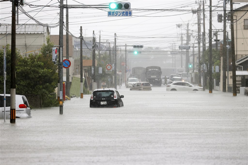 福岡縣太牟田市街道車輛受困積水中。(共同社提供)
