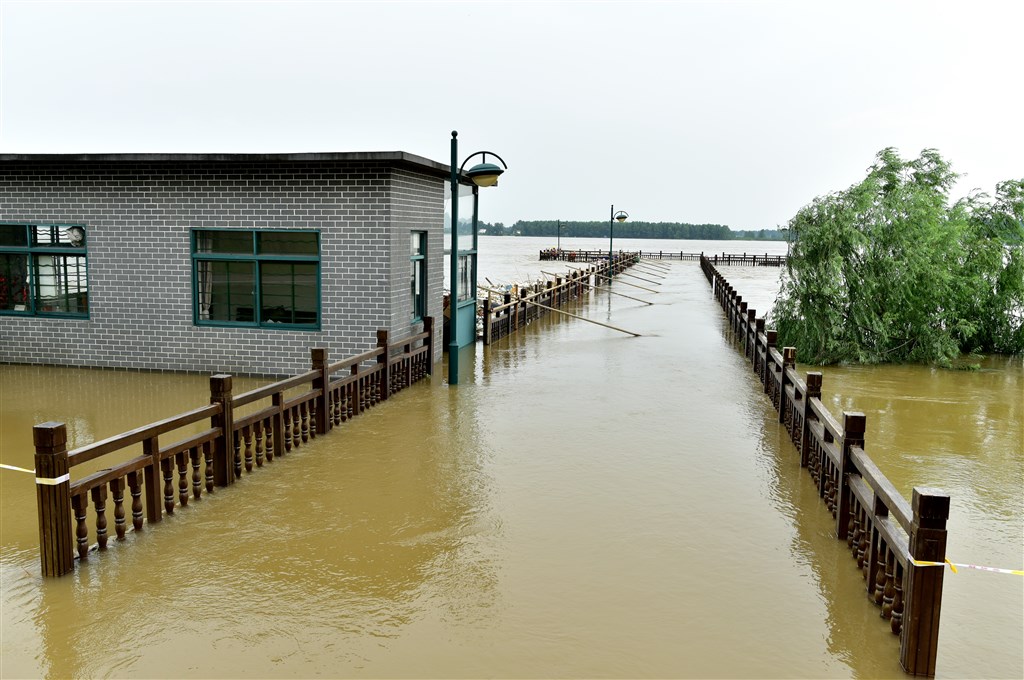 中國長江流域豪雨不斷,7日安徽銅陵一處濱江公園中的橋面已被江水淹過。(中新社提供)