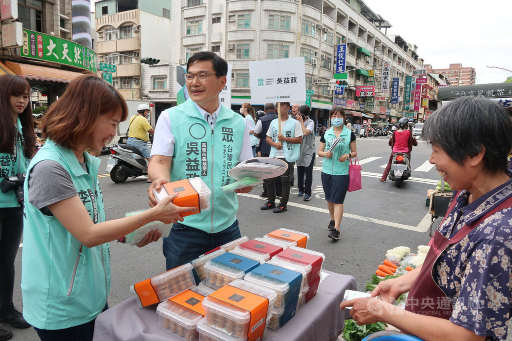 台灣民眾黨高雄市長補選參選人吳益政(前中)9日到陽明市場拜票,沿路發放扇子及口罩,爭取支持。中央社記者王淑芬攝 109年7月9日