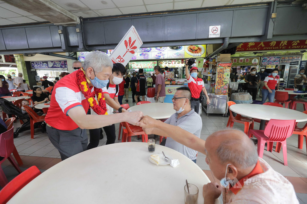 新加坡10日將舉行大選,圖為加入反對黨新加坡前進黨的李顯揚(左)在5日陪同候選人走訪選區。中央社記者黃自強新加坡攝 109年7月9日
