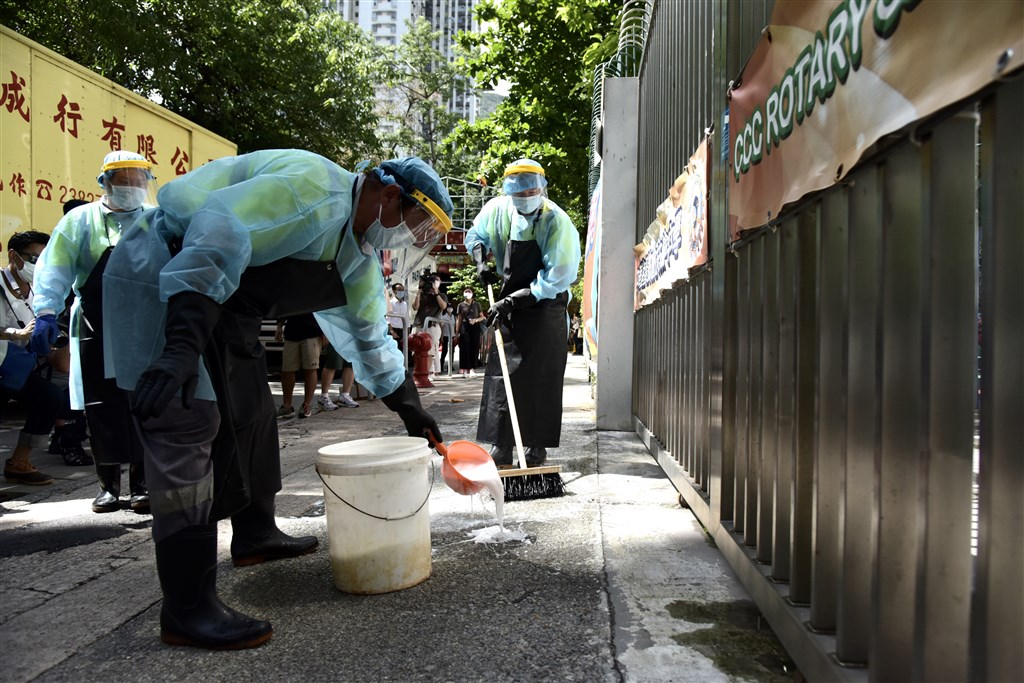 香港新冠肺炎病例增加,當局決定本地中小學和幼兒園13日起提前放暑假。圖為清潔人員在中華基督教會扶輪中學附近消毒。(中新社提供)