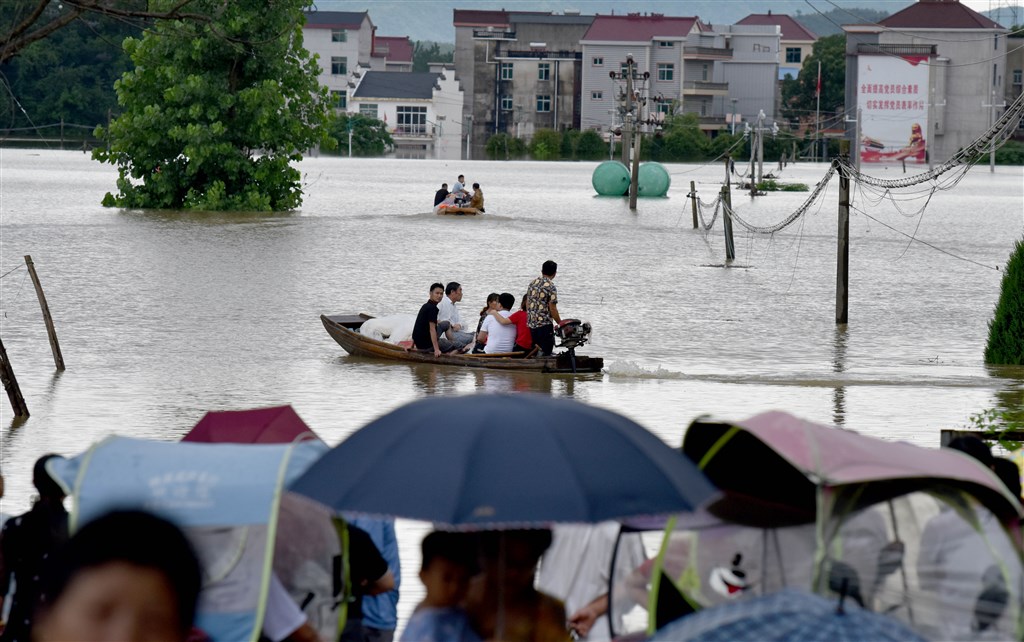 江西省景德鎮樂平市7條河川水位因大雨上漲,民眾因道路被水淹沒乘船撤離,當地洪災至9日影響逾10萬人。(中新社提供)