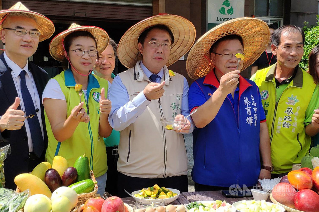 台南市長黃偉哲(中)12日在新營區協助農民叫賣,支持採友善耕作方式的多種農產品。中央社記者楊思瑞攝 109年7月12日