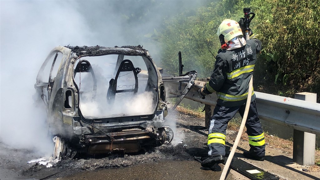 國道3號北上新竹縣芎林路段12日一輛自小客車停在路肩,不久後車輛竟自燃,警消獲報趕往現場拉水線灌救,但車已被燒得僅剩骨架,起火原因待查。(讀者提供)中央社記者魯鋼駿傳真 109年7月12日