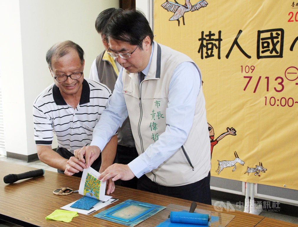 台南市長黃偉哲(右)13日出席在中西區南美里活動中心舉辦的樹人國小師生版畫特展開幕儀式,現場體驗版畫製作過程。中央社記者楊思瑞攝 109年7月13日