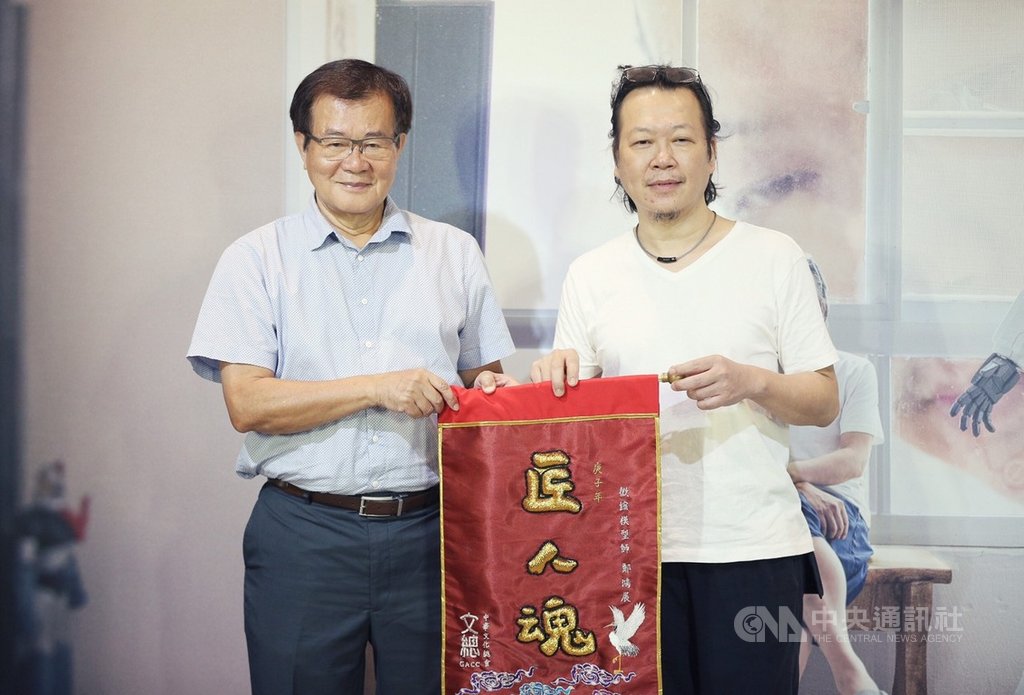 中華文化總會「匠人魂」系列短片,13日舉辦第23集「微縮人生」影片發布記者會,介紹台灣微縮模型達人鄭鴻展(右),中華文化總會副會長江春男(左)頒授「匠人魂」錦旗給鄭鴻展。(文化總會提供)中央社記者葉冠吟傳真 109年7月13日