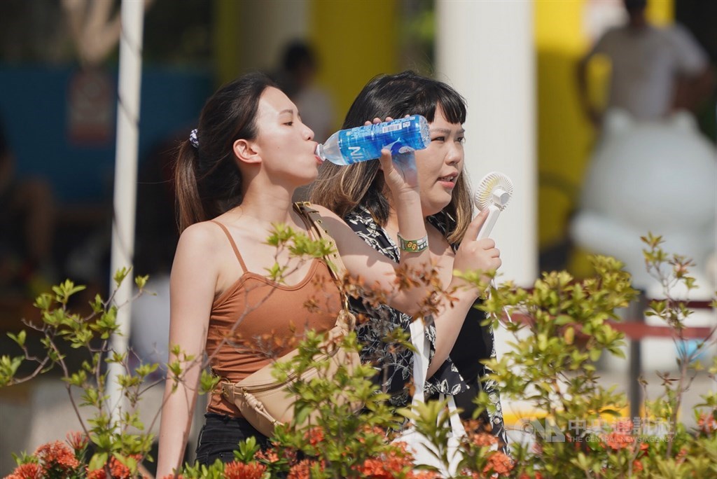 根據中央氣象局觀測,台北測站13日中午11時59分氣溫達攝氏38.9度,創下歷年7月最高溫紀錄,北市民眾在戶外喝飲料補充水分,也有人以隨身電扇消暑。中央社記者徐肇昌攝 109年7月13日