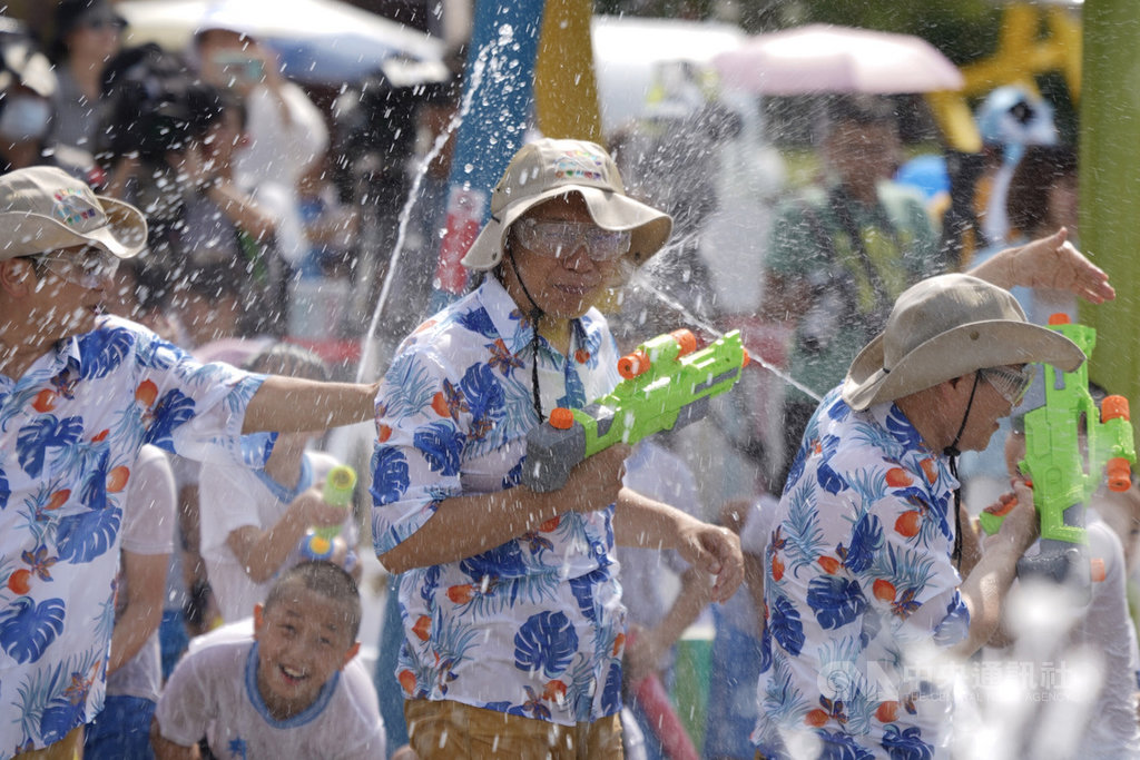 台北市兒童新樂園「小小水樂園」13日起正式開幕,台北市長柯文哲(中)到場與民眾同樂,被小朋友們以水槍強力噴射。中央社記者徐肇昌攝 109年7月13日