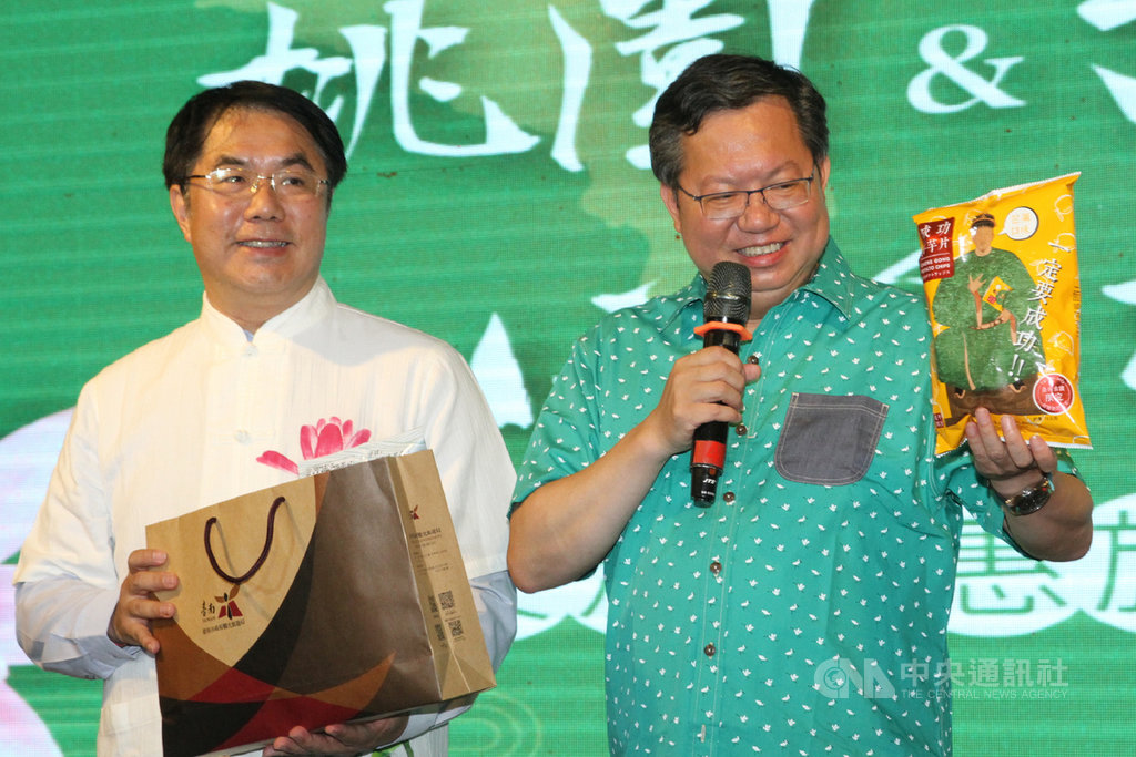 桃園市長鄭文燦(右)13日帶領里民活動團參訪台南,台南市長黃偉哲(左)晚間設宴歡迎,2人互贈代表地方的文創商品及農特產品,象徵雙方深化交流,盼兩座城市合作拚觀光。中央社記者楊思瑞攝 109年7月13日