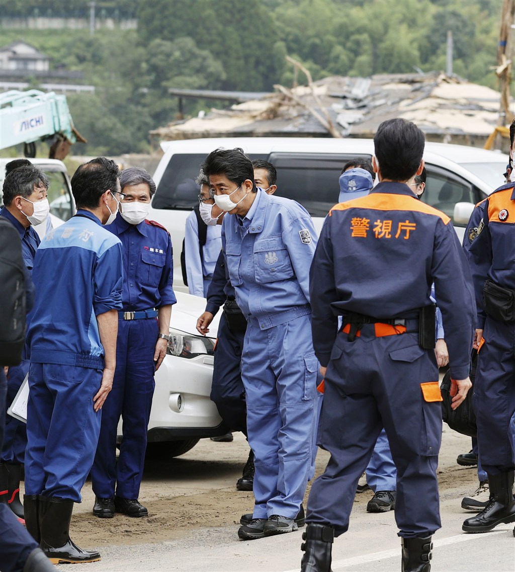 日本許多地區過去一週受豪雨重創,其中以九州地方的熊本縣南部受災最為嚴重,首相安倍晉三(中)13日上午搭機前往災區視察,並承諾全力協助地方政府重建。(共同社提供)