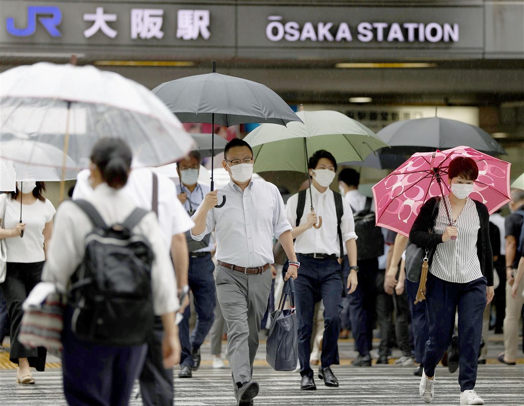 日本疫情持續升溫,東京都連4天單日破200例,大阪府由於新增病例超過「大阪模式」標準,12日晚間在知名地標點亮黃燈示警。(共同社提供)