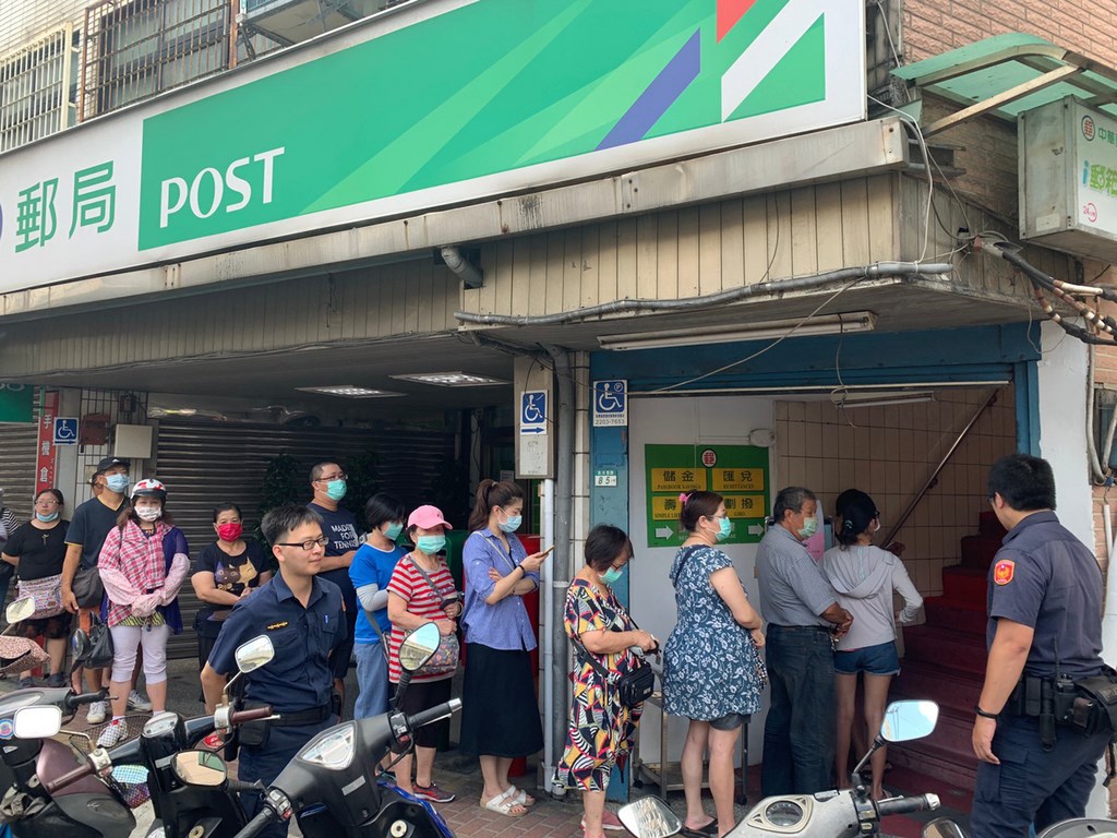 民眾15日起可到全台1299間郵局購領紙本振興三倍券,新莊區郵局一早就出現排隊領取三倍券的人潮。(警方提供)中央社記者葉臻傳真 109年7月15日