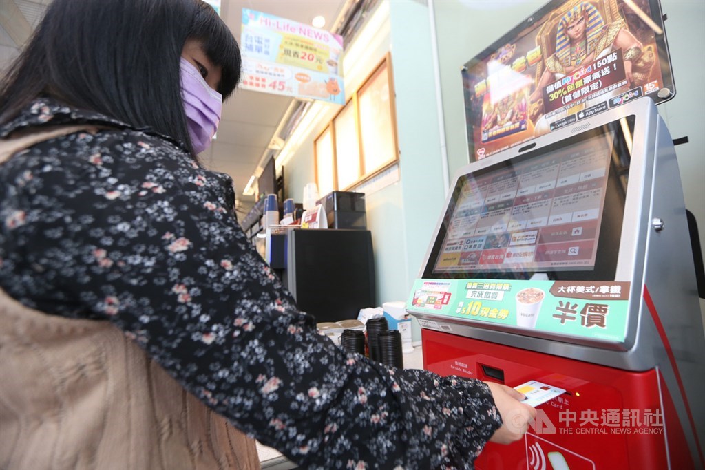 振興三倍券15日正式上路,民眾到4大超商指定門市,在事務機點選「振興三倍券」快速鍵,並在機台下方插入健保卡。中央社記者鄭傑文攝 109年7月15日