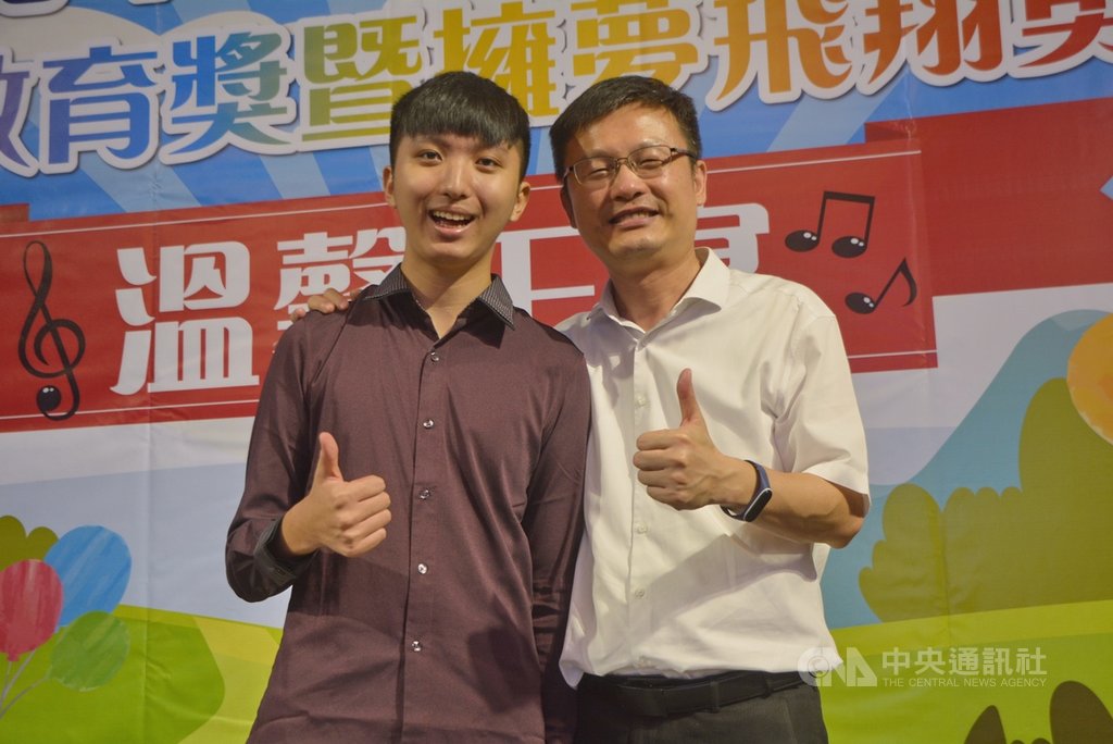 獲2020總統教育獎的清華大學生吳承澐(左)幾近全盲,16日在新北市政府以指尖的音樂分享他永不放棄的生命故事,並致贈鋼琴專輯給新北市教育局長張明文(右),獲得全場熱烈掌聲。中央社記者黃旭昇新北攝 109年7月16日