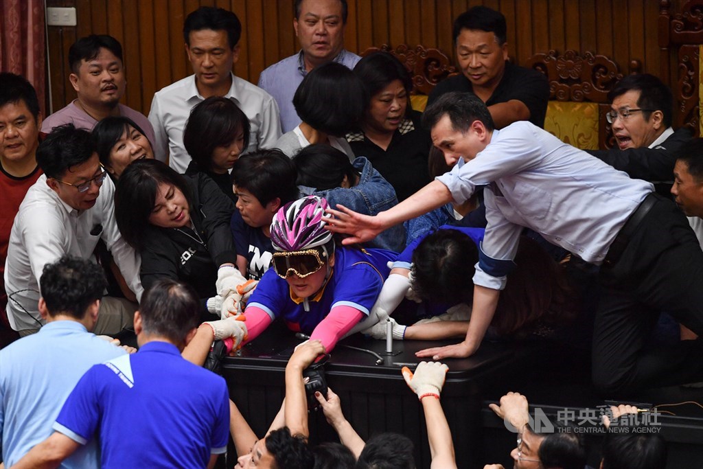 監察院人事案同意權投票在即,民進黨籍立委16日下午強勢清場,將占領主席台的國民黨籍立委逐一拉開,藍委陳玉珍(粉色安全帽者)緊貼台上不願離去。中央社記者林俊耀攝 109年7月16日