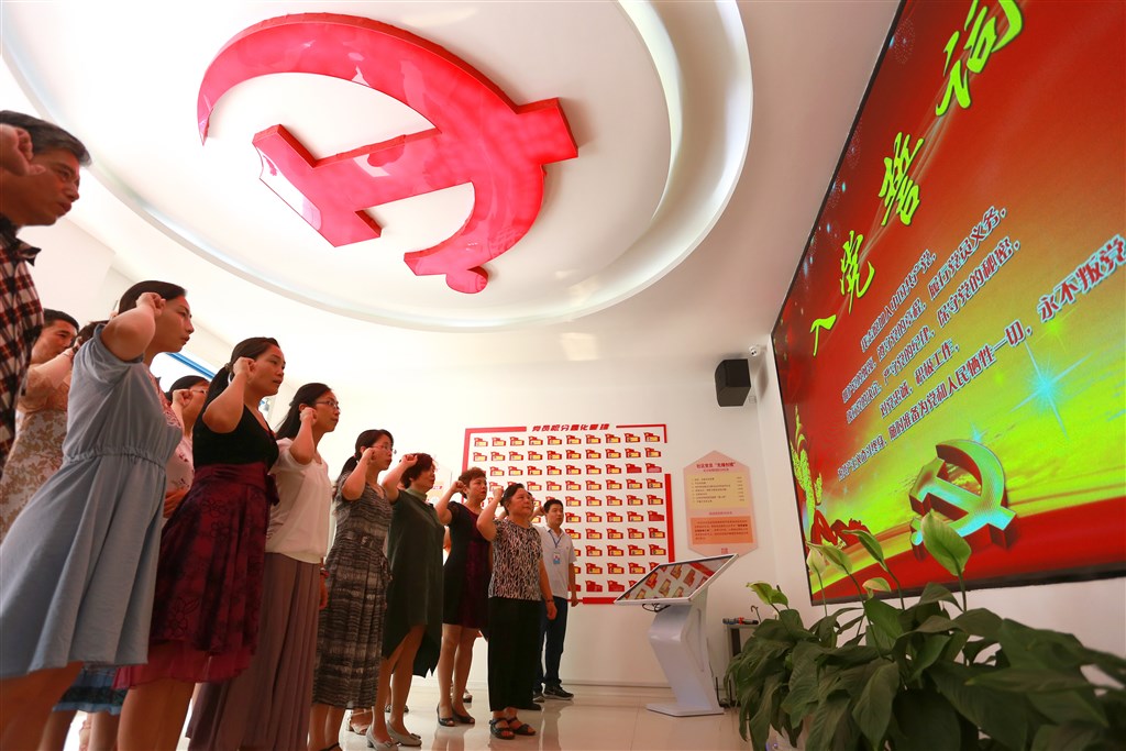 近幾十年有許多中國公民為了做生意、研究學術甚至發展藝文入黨。圖為山東一群社區黨員重溫入黨誓詞。(檔案照片/中新社提供)