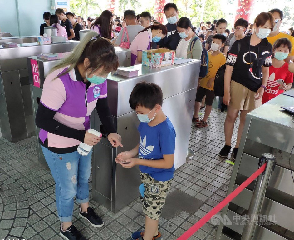 安心旅遊針對19歲以下學生,7、8月不限次數遊全台22家樂園,因補助經費月底恐用完,傳業者要提前收費。交通部長林佳龍指示,優惠不能喊停。圖為園方動員在入口協助遊客測量體溫及手部消毒,落實防疫。(中央社檔案照片)
