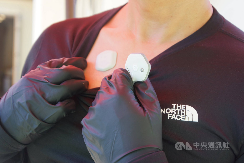 貼在前胸的生物貼片BioButton(左側貼片),為美國科技新創公司BioIntelliSense研發的二代產品,除能精準搜集人體生理數據,同時兼具武漢肺炎防疫的接觸史追蹤功能。圖為美西時間16日對媒體展示產品。中央社記者周世惠舊金山攝 109年7月18日