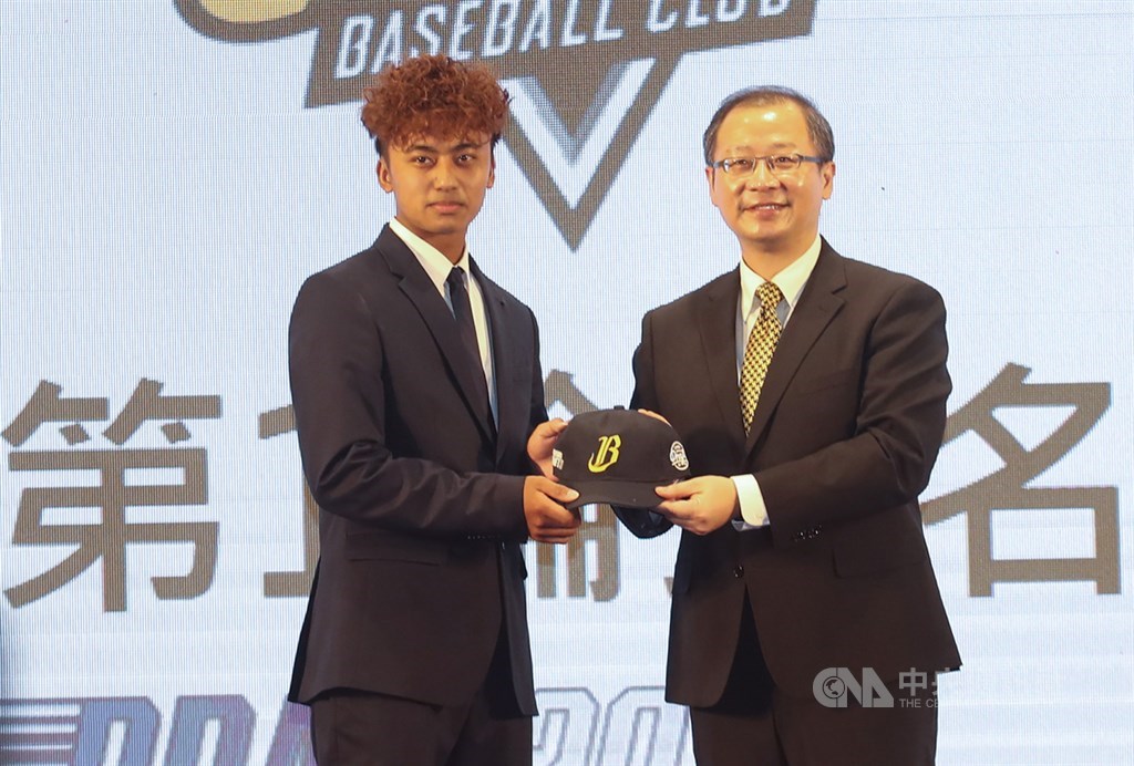 2020中華職棒新人球員選拔會20日在台中登場,中信兄弟在第一輪第4順位指名余謙(左),中職會長吳志揚(右)送上球帽。中央社記者張新偉攝 109年7月20日