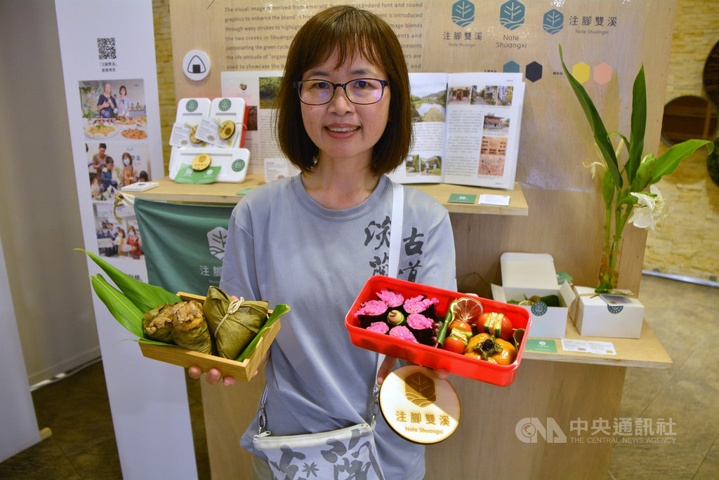 新北農業創生計畫成果展24日在板橋登場,注腳雙溪工作室負責人簡淑慧現場展示堅持有機的品牌設計LOGO,以及團隊設計的淡蘭古道行動糧食野薑花粽、幫助小農的淡蘭飯包等。中央社記者黃旭昇新北市攝 109年7月24日