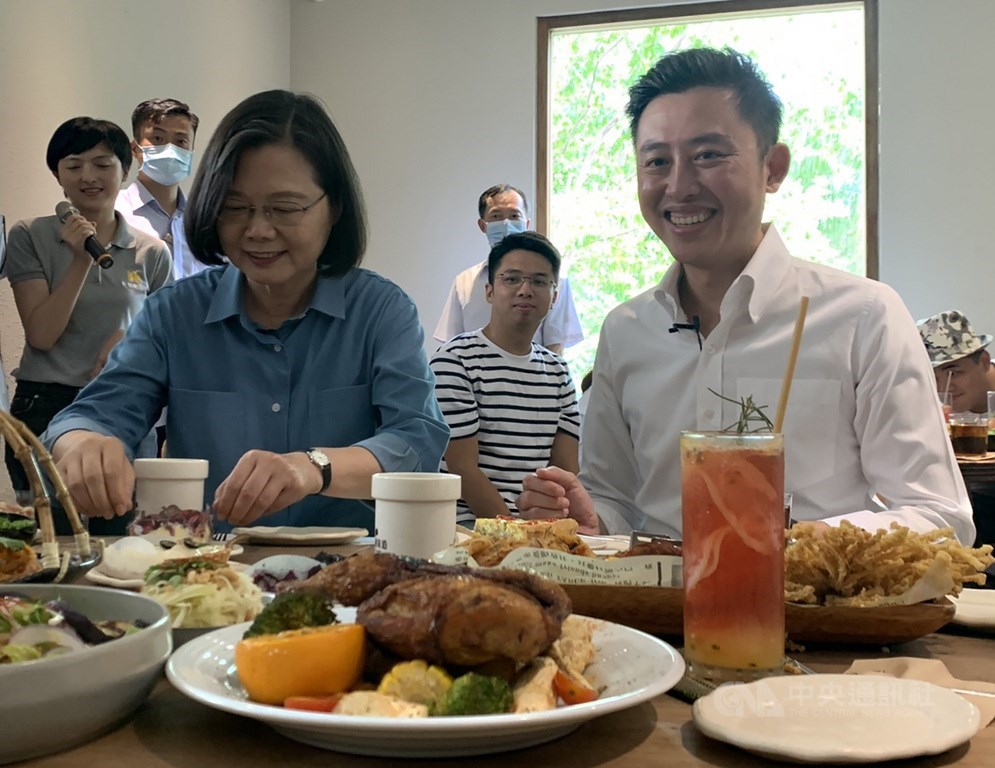 總統蔡英文(前左)21日在新竹市長林智堅(前右)陪同,到新竹市使用振興三倍券消費,購買不少在地美食,開心享用。中央社記者郭宣彣攝 109年7月21日