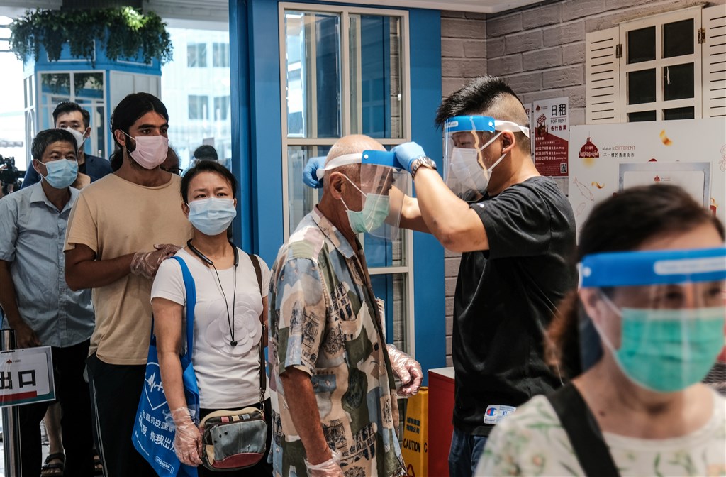 香港武漢肺炎疫情轉趨嚴峻,北京當局31日宣布,北京中央決定應香港方面要求派遣檢測人員赴港協助展開大規模核酸檢測篩查。圖為29日香港慈雲山市場人員為入場市民測量體溫。(中新社)