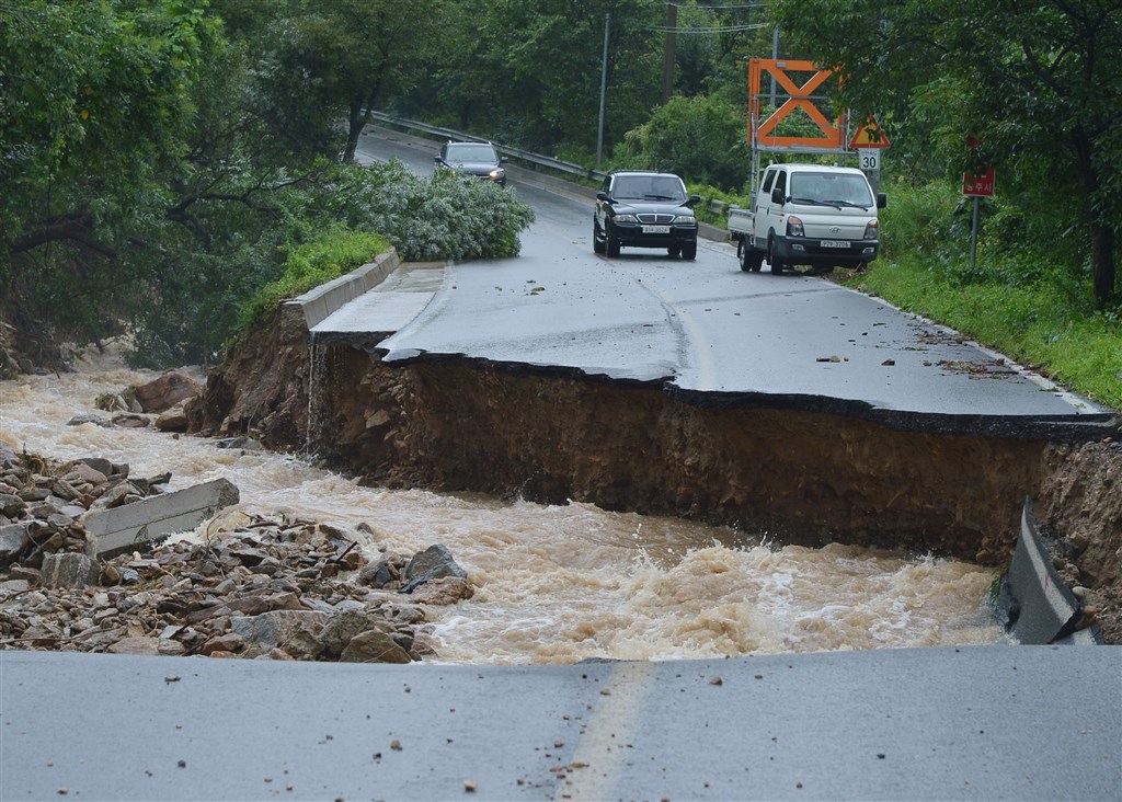 韓國中部強風暴雨成災，忠清北道忠州市2日一處道路坍塌。（韓聯社）