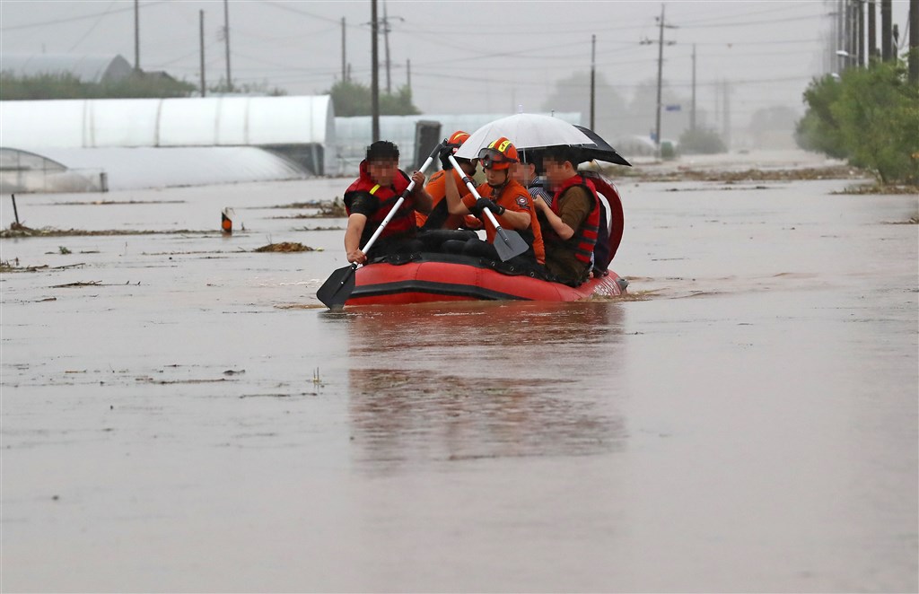 連日豪雨引發韓國洪災,根據當局統計,至今已造成至少13人喪生,超過1000名受災民眾流離失所。圖為3日天安市村民搭乘橡皮筏脫困。(韓聯社)