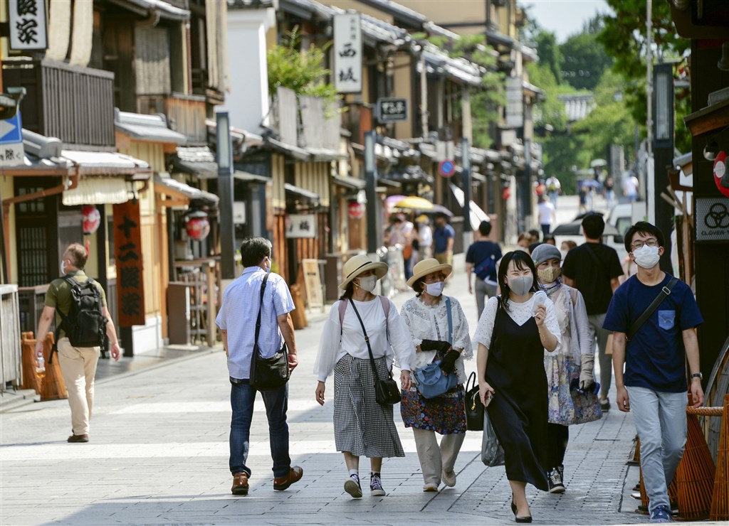 日本47個都道府縣中,昨天有40個共新增1240例確診病例,其中東京都新增病例有約一成發生在家中。圖為京都民眾戴口罩上街。(共同社)