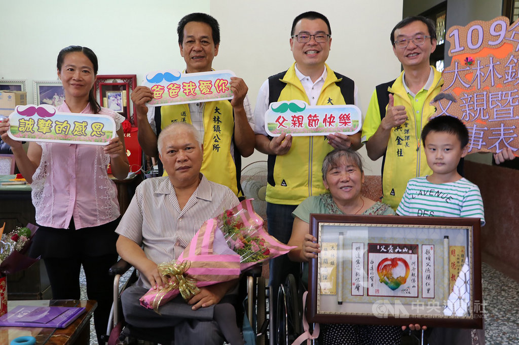嘉義縣大林鎮民簡崑楠(前左)因小兒麻痺造成雙腳殘疾,身處逆境仍堅強以對,學習裁縫成家立業,以精湛手藝撫養兒女長大成人,榮獲109年嘉義縣模範父親肯定,大林鎮長簡志偉(後右2)6日前往祝賀。(大林鎮公所提供)中央社記者蔡智明傳真 109年8月6日