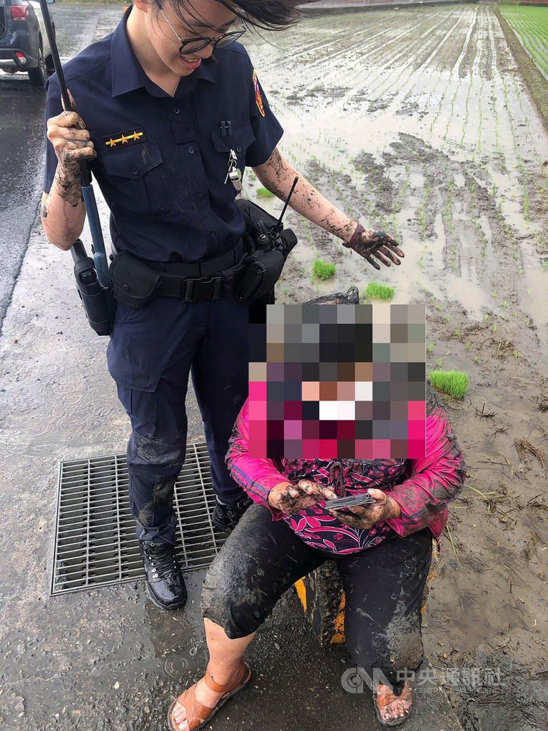嘉義縣警員張伊謦(左)日前巡邏時,發現一名婦人騎車摔落水田,立即停車救援。由於當時下著大雨,為了救人,張伊謦不僅全身濕透,泥巴還沾滿全身,婦人對於警方協助也相當感激。(警方提供)中央社記者蔡智明傳真 109年8月7日